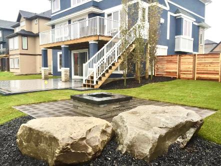 Fence and fire pit landscape construction in Calgary backyard