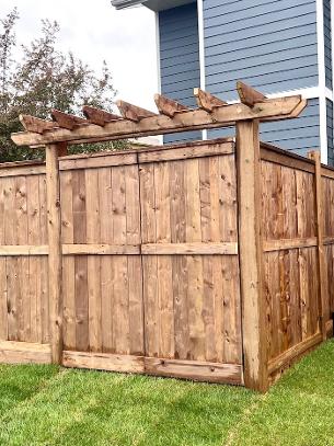 Custom Wood Fence construction with oversized gate and decorative arbor in Calgary Backyard
