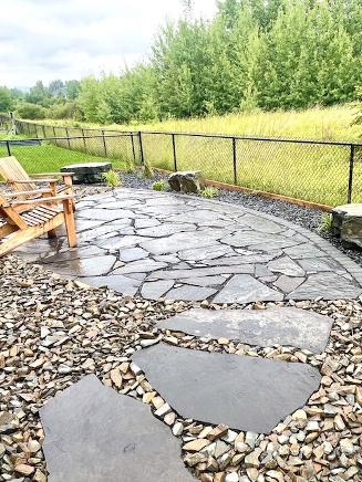 Flagstone and natural rock landscaping in Cochrane backyard