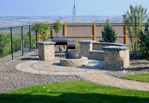 Fire pit with build-in bench seating construction in Calgary backyard