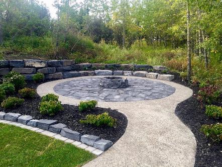 Fire pit and patio with garden bed construction in Calgary backyard