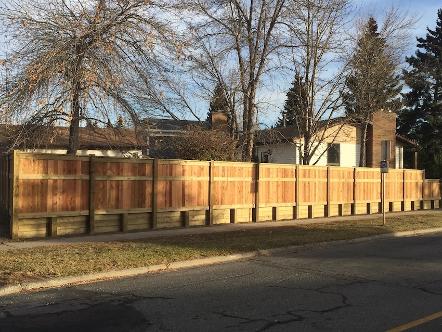 Wood retaining wall with fence construction in Calgary backyard