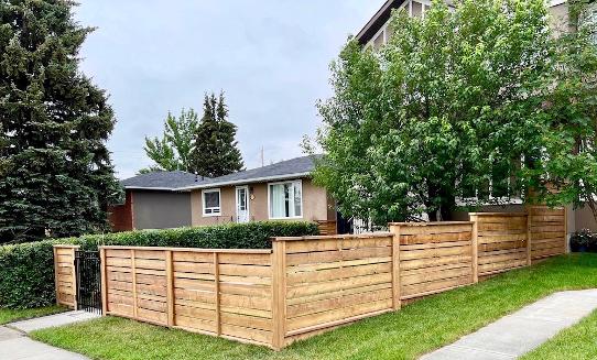 Modern horizontal wood fence construction in Calgary yard