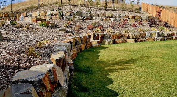 Large tiered natural stone retaining wall construction in Calgary acreage
