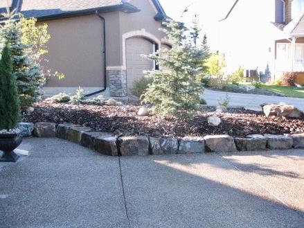 Natural stone garden bed construction in Calgary front yard