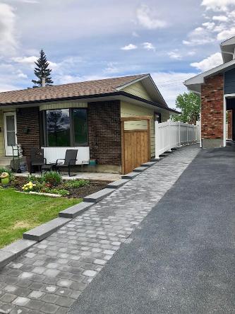 Retaining wall and paving stone driveway extension construction in Calgary front yard