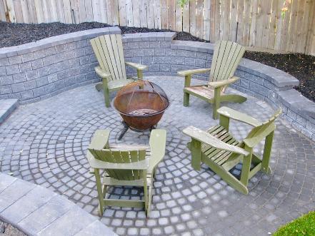 Sunken fire pit area with retaining wall and paving stone patio construction in Calgary backyard